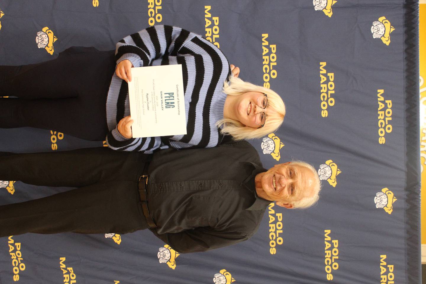 Ryplee Custer (left) receives a $500 PFLAG scholarship from PFLAG member Charlie Gall.