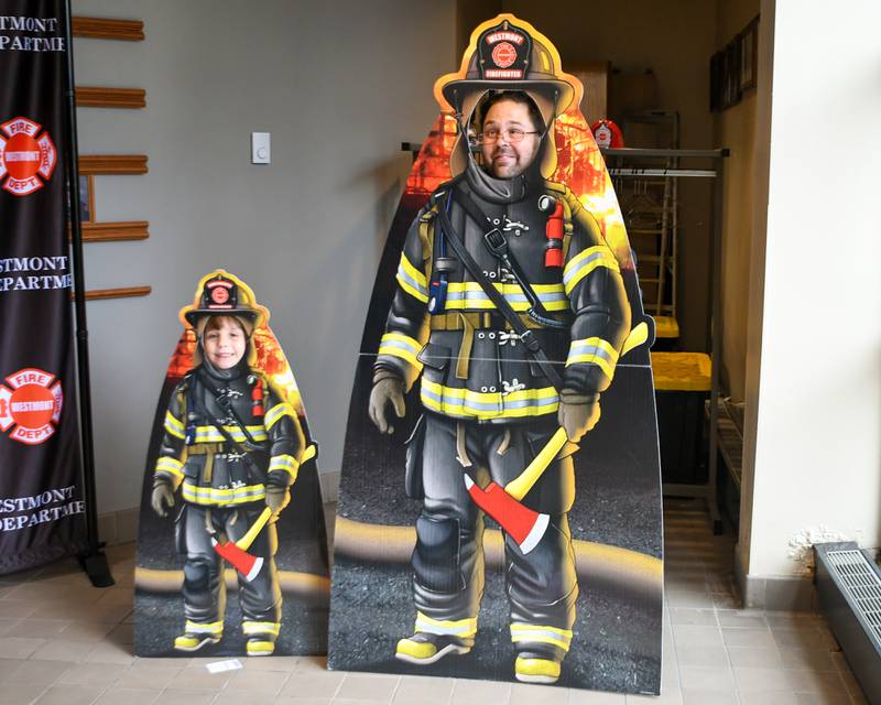 Eric Fasbender and his 6 year old son Carson Fasbender of Westmont pose for a photo with firefighter cutouts during the Westmont fire department 100 year anniversary open house held on Saturday Oct. 14, 2023.