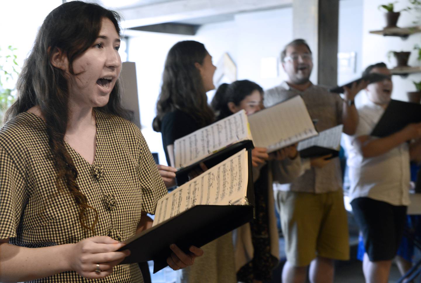 Natalie Mustea (foreground) sings "Bridge Over Troubled Water" along with her fellow choral members during a special coffeehouse concert Wednesday, June 22, 2022, at More On Main in Streator as part of the Poco a Poco Festival.