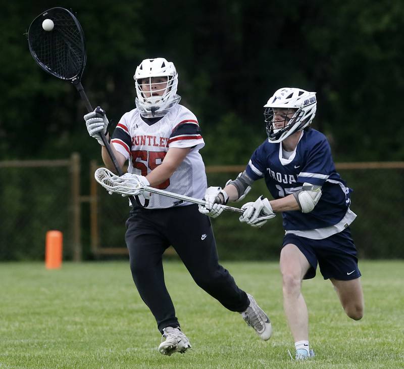 Huntley's Anthony Taylor passes the ball as he is guarded by Cary-Grove's Evan Lamb during the Marian Central Sectional boys lacrosse semifinal match on Wednesday, May 28, 2025, at Marian Central High School in Woodstock.