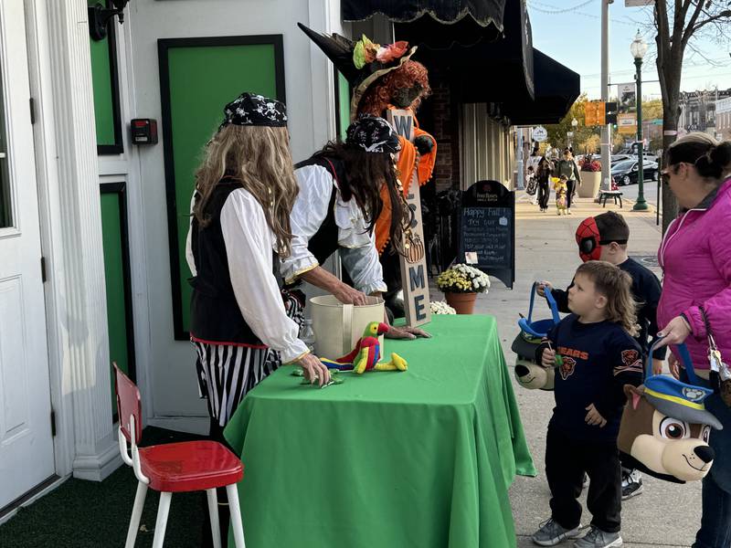 Apple Butter and Shugie's hands out candy to football player Xander and Anthony, dressed as Spider-man.