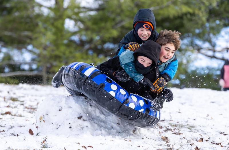From top to bottom: Hansel Sroufek, 10, Giovanni Chiarito, 12, and Wolfgang Sroufek, 12, sled over a ramp made of snow at Fabyan Forest Preserve in Geneva after a snowfall on Friday, Dec. 20, 2024.