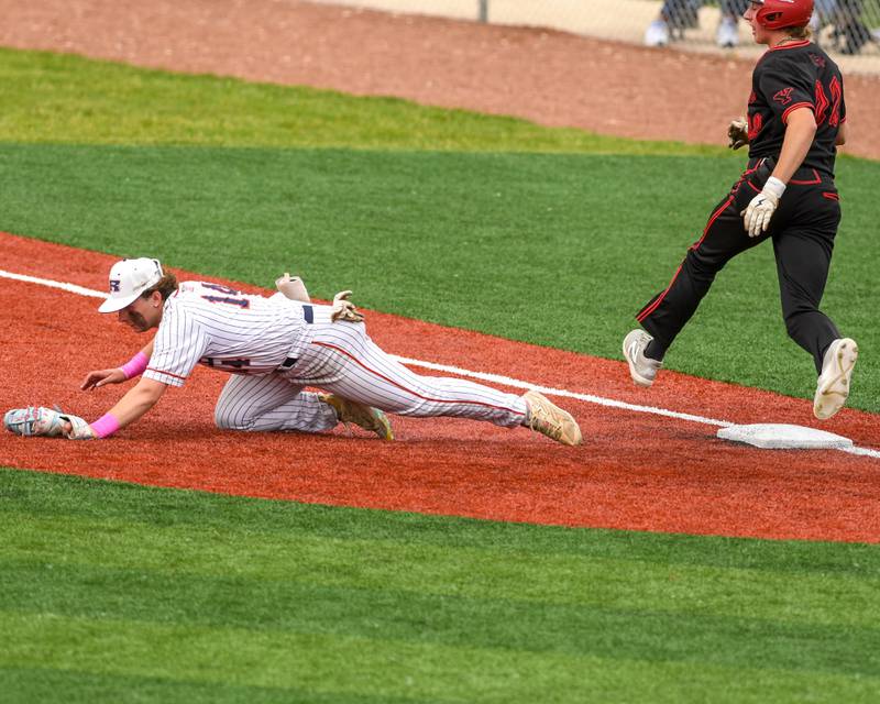 Romeoville's Nate Lubinski (14) comes off the bag with the ball allowing Yorkville Aaron Klemm (22) to get a base hit safely during the regional game on Thursday May 29, 2025, held at Yorkville High School.