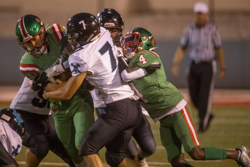 Seth Adams gains a few extra yards while being wrapped up by a group of three Woodstock North defensemen at Howard Fellows Stadium on Sept. 8, 2023.