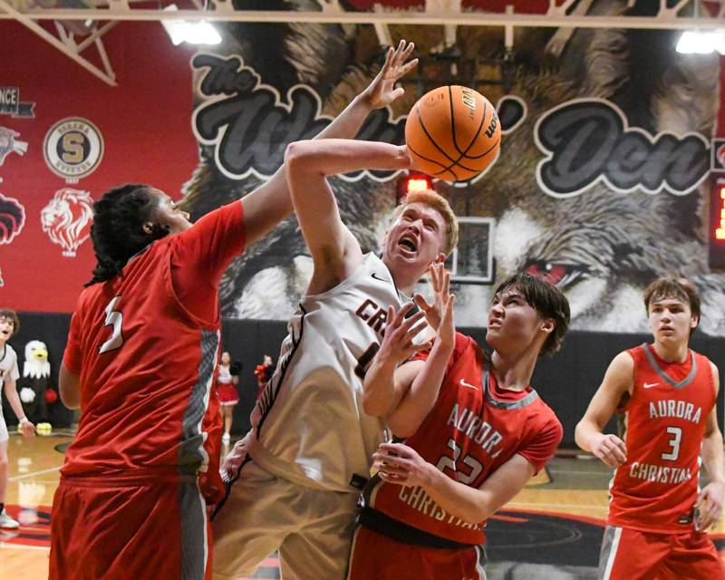 Indian Creek's Everett Wills, center, gets fouled while taking a shot by Aurora Christian's Jordan Weeks, left, during the game on Wednesday Feb. 26, 2025, held at Indian Creek High School.