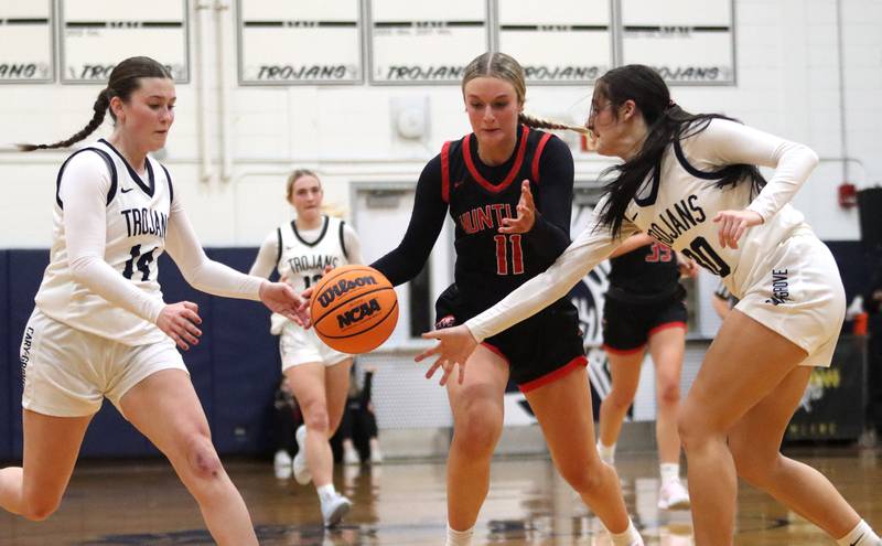 Huntley’s Anna Campanelli, center, navigates heavy traffic   in varsity girls basketball on Friday, Jan. 24, 2025, at Cary-Grove High School in Cary.