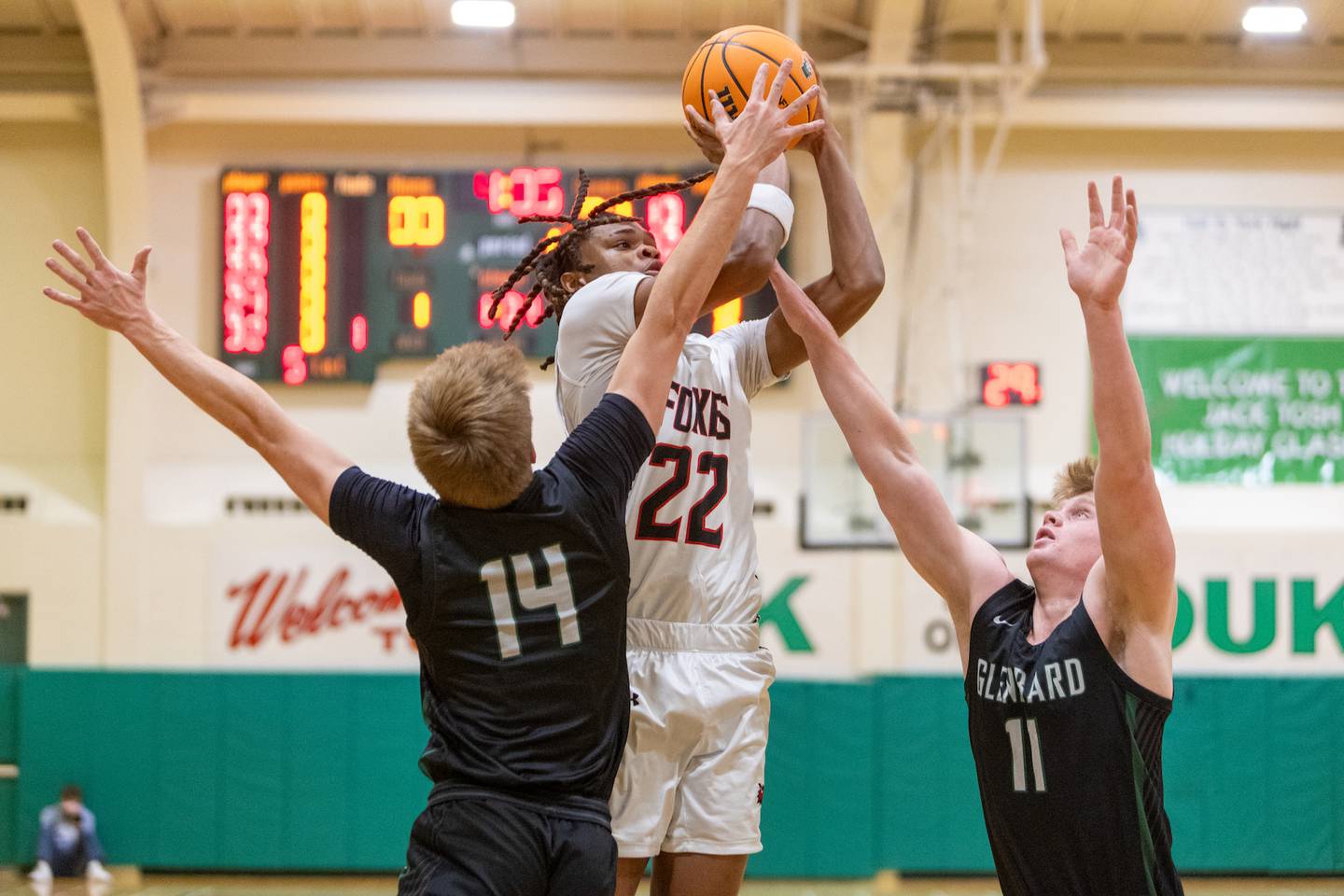 Yorkville's Braydon Porter shots a jumper over Glenbard West's Finn Sheeley (14) and Chase Cavan (11) on Friday Dec. 26,2025 at the 51st. Annual Jack Tosh Holiday Tournament in Elmhurst.