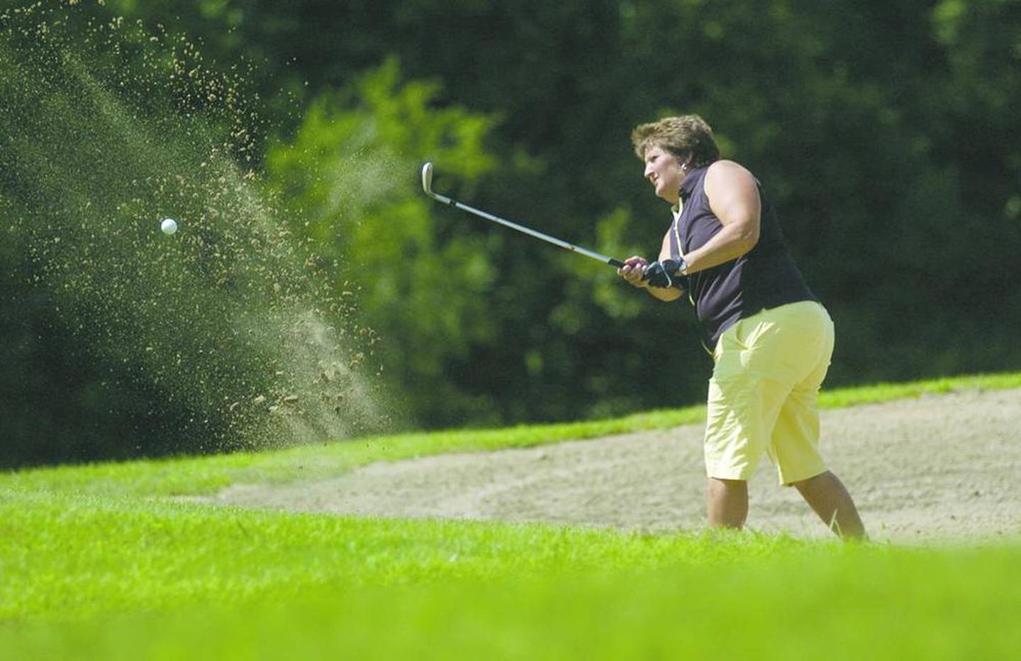 Cheri Russell blasts her way out of the sand trap on the 18th hole to finish out her championship in Sunday's IVWG Open at Senica's Oak Ridge Golf Course in LaSalle.