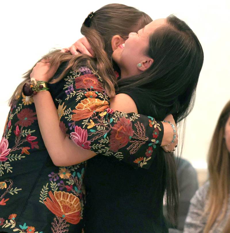 Athena Award finalist Linh Nguyen (right) gets a hug on her way up to be recognized Tuesday, Oct. 18, 2022, during the Athena and Women of Accomplishment Award reception at the Barsema Alumni and Visitors Center at Northern Illinois University in DeKalb.