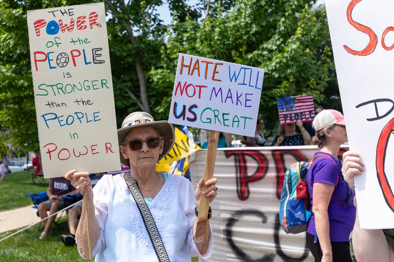 Protester holds signs at the “No Kings” protest on Saturday, June 14, 2025 at Rotary Park in Princeton.