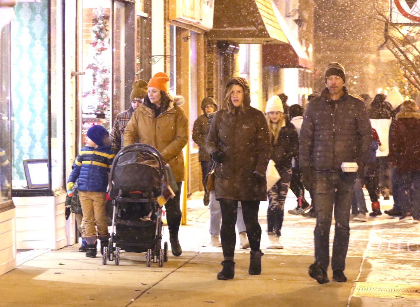 Visitors walk through a light snow Friday, Nov. 18, 2022, during the Sycamore Chamber of Commerce's annual Moonlight Magic event in downtown Sycamore.