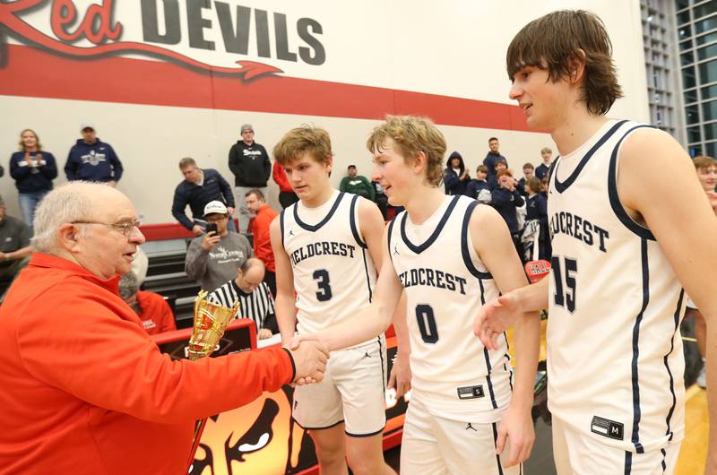 Frank Colmone hands Fieldcrest players Edmond Lorton, Jordan Heider and Brady Ruestman the first-place trophy after winning the 49th annual Colmone Classic on Saturday, Dec. 9, 2023 at Hall High School.