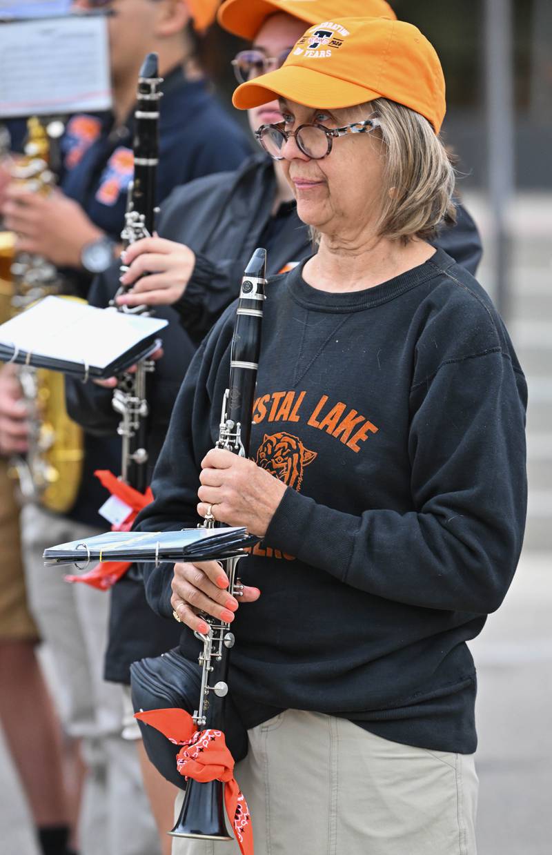 Lisa Gieseke Sadlik, class of '73, joins the Crystal Lake Central H.S. marching band at the start of their 100th anniversary homecoming day parade that featured alumni from various graduating classes on a rainy Saturday, Sep. 16, 2023 in Crystal Lake. The parade began at the high school and made its way through downtown Crystal Lake.
