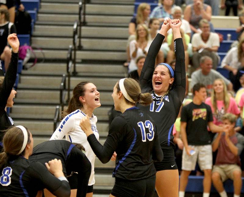 St. Charles North's Daley Krage (17) celebrates with the team after their last point in a 25-11, 25-13 win over Geneva Tuesday night.