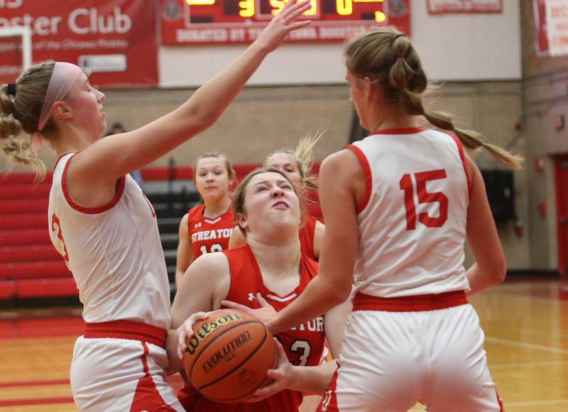 Streator's Leah Krohe eyes the hoop while she's met in the lane by Ottawa's Skylar Dorsey and Hailey Larsen.