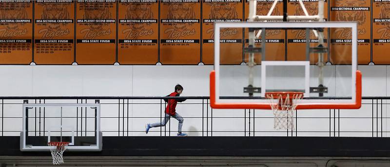 A boy runs around the track on Friday, Feb. 7, 2025, during a Fox Valley Conference girls basketball game between.Crystal Lake Central and Hampshire on Friday, Feb. 7, 2025, at Crystal Lake Central High School.