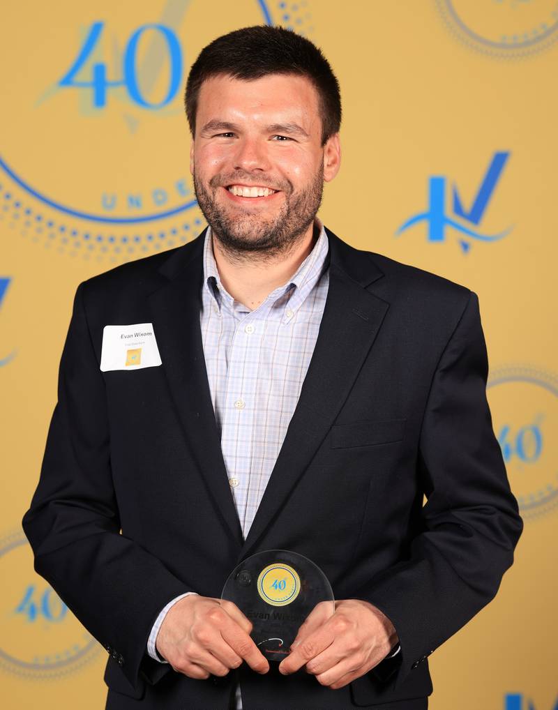 Evan Wixom poses with his 40 Under Forty award during the Illinois Valley Chamber of Commerce Champions of Change Awards Night on Thursday, April 10, 2025 at the Westclox Event Center in Peru.