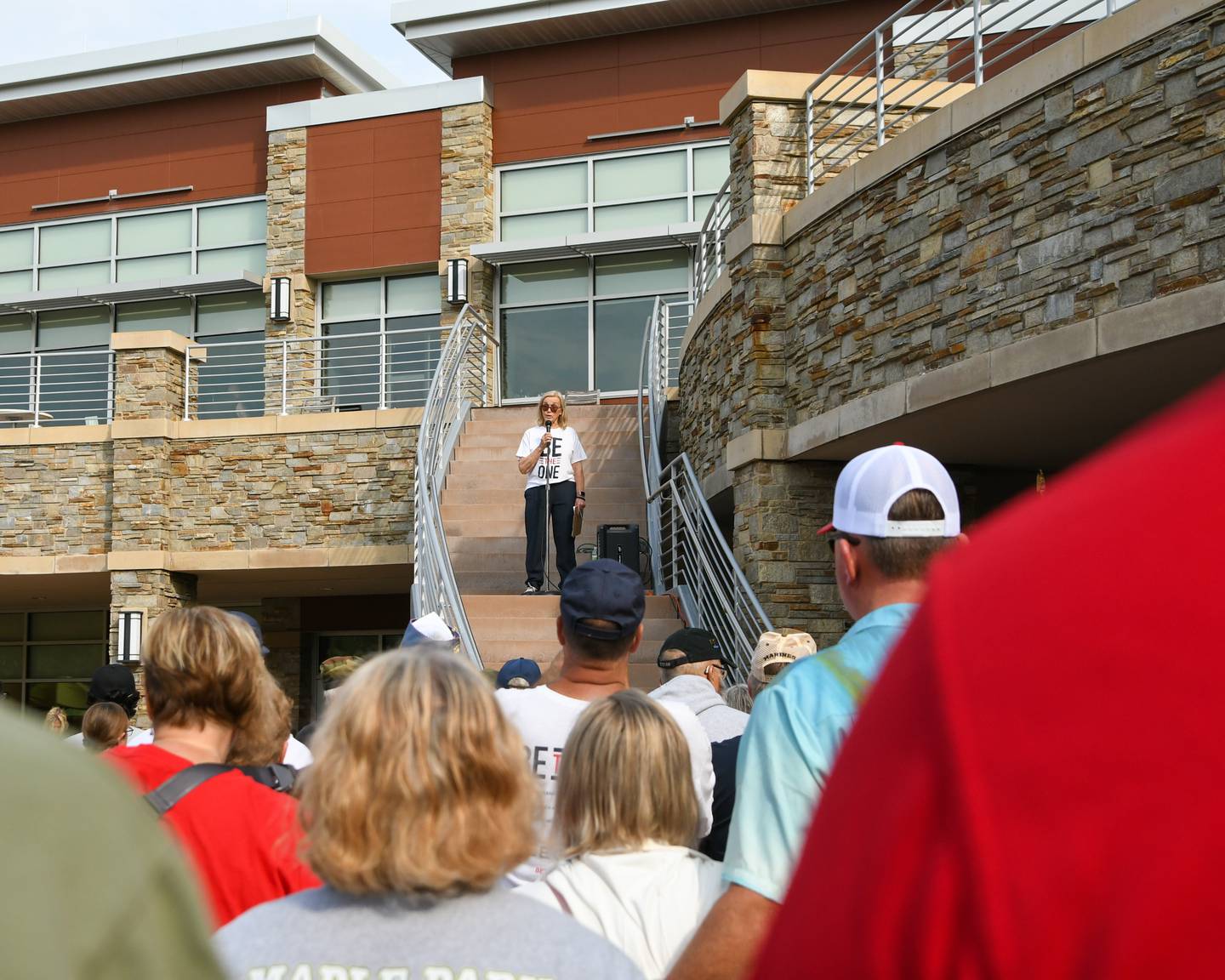 Participants listen as organizer Cindy Hupke of the American Legion Post No. 66 in DeKalb talks on Sunday, Sept. 21, 2025, before the start of the second annual Be the One Walk to end veteran suicide held at the Northwestern Medicine Kishwaukee Health and Wellness Center in DeKalb.