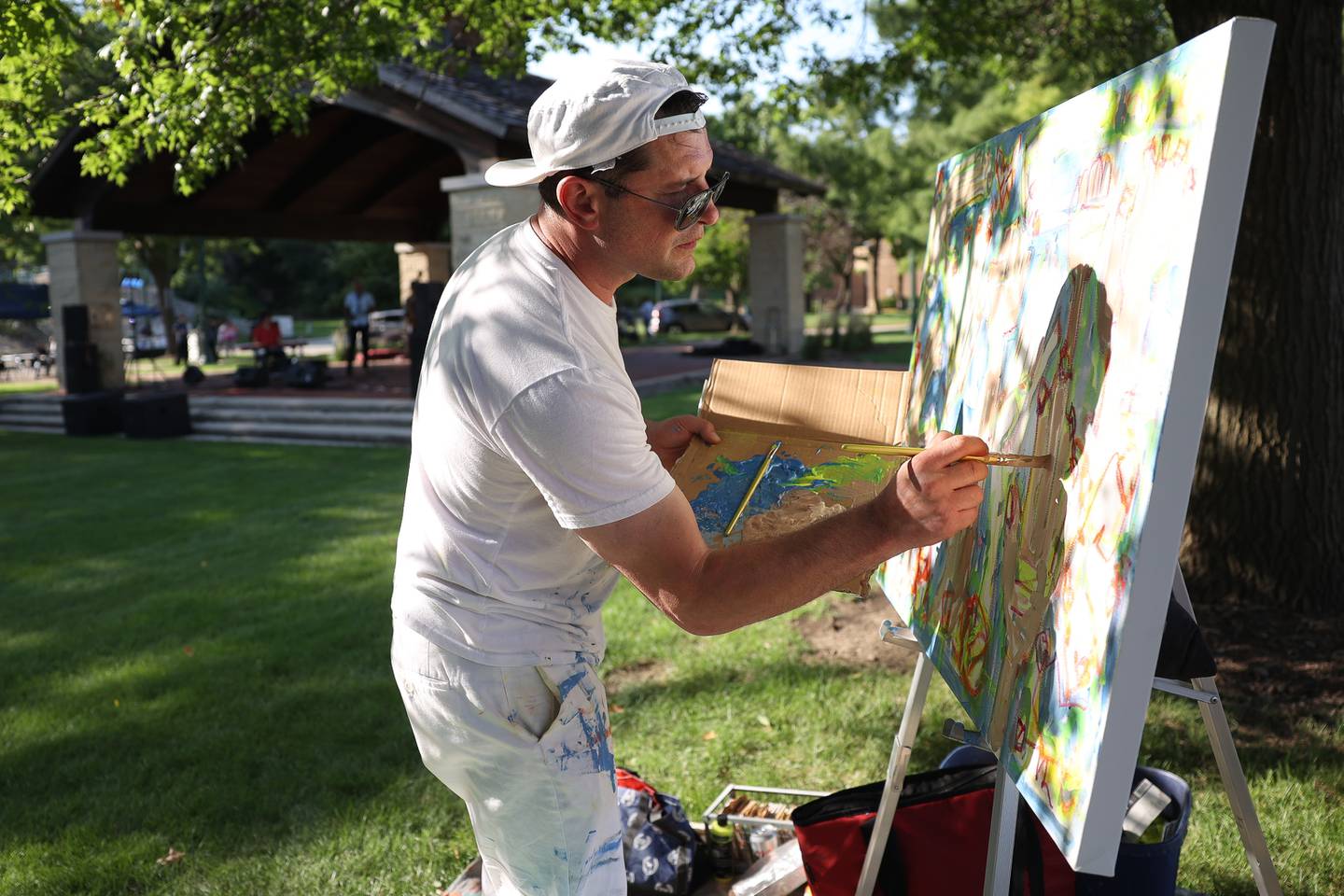 Artist Matt Jesiolowski works on a painting at the Wine, Jazz and Arts Fest at Bicentennial Park in Joliet on Saturday, Aug. 19, 2023.