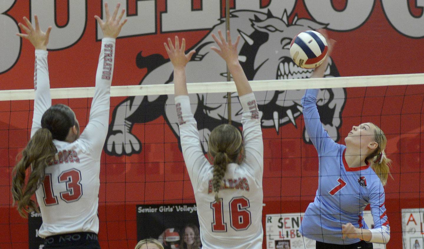 Ottawa’s Ryleigh Stevenson sets to spike while Streator’s Mya Zavada and Devin Elias prepare to block in the first match Thursday at Streator.