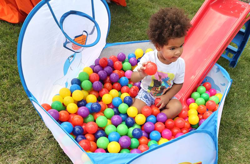 Amari'lee Rogers, 2, from DeKalb, plays in the ballpit at the Westside Children's Therapy booth Thursday, July 21, 2022, during the DeKalb Chamber of Commerce Family Fun Fest at Hopkins Park in DeKalb.