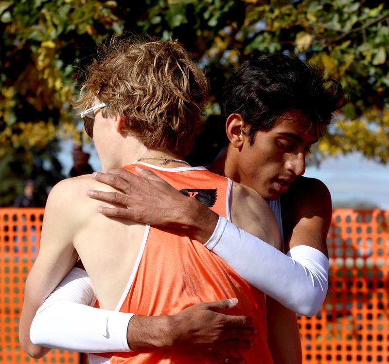 Woodstock’s Ishan Patel is congratulated after a boys Class 2A Sectional Cross Country Meet at Emricson Park in Woodstock Saturday.
