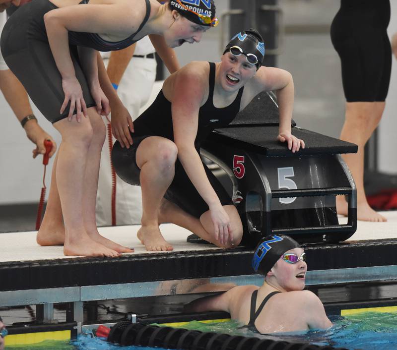St. Charles North 400-yard relay anchor Isabelle Beu, in water, views her team’s winning time during the IHSA girls state swimming finals at FMC Natatorium in Westmont on Saturday, Nov. 12, 2022.