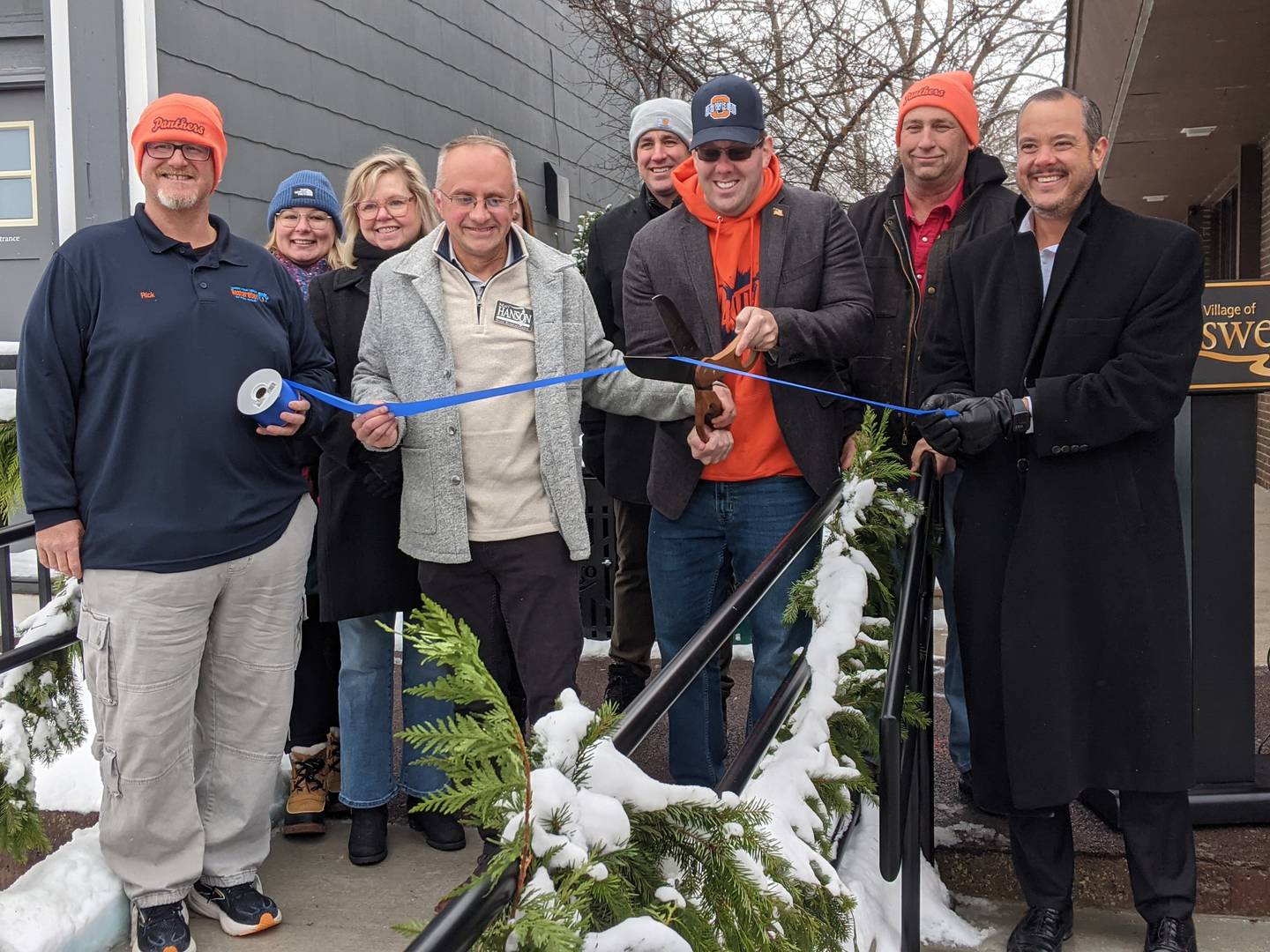 Oswego Village President Ryan Kauffman cuts the ribbon on a new ADA compliant ramp on Main Street in downtown Oswego during a ceremony on Dec. 3, 2025.