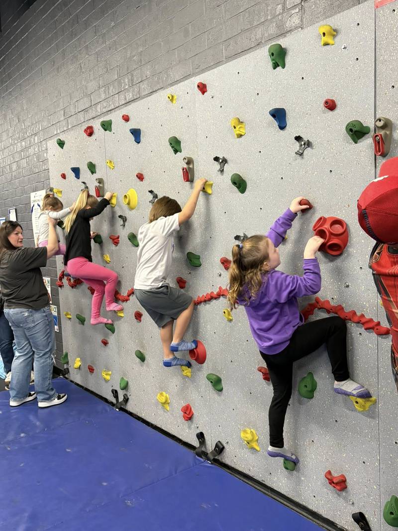 Children climb a fitness wall Saturday, April 26, 2025, during Healthy Kids Day at the Streator YMCA.