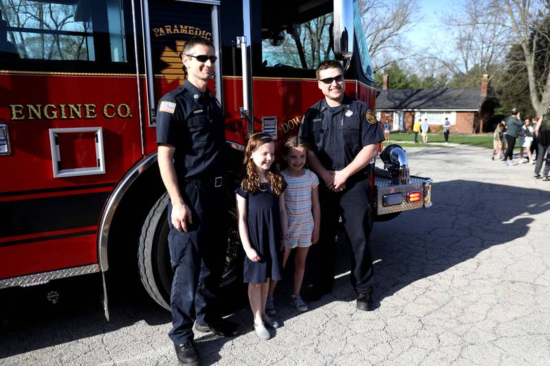 Belle Aire Elementary School third-grader Kyla Richardson  (second from left) and her sister, first-grader Laina Richardson, pose with Downers Grove firefighter/paramedics Kris Nowak (left) and Tyler Thiessen after the girls got a ride to the Downers Grove school in a fire truck on Thursday, April 13, 2023. Kyla won the trip by entering a contest sponsored by the  Fire Department as part of the Learn Not to Burn program.