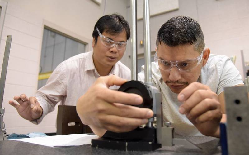 Smithfield Food apprentices Jaime Suarez, up front, and Swan Tuang work with a height gauge during an industrial manufacturing class at Elgin Community College.