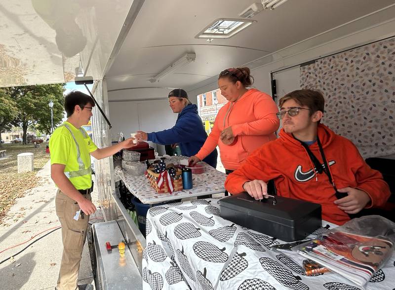Volunteers from the Let Freedom Ring Festival serves a cup of hot cocoa to Bryan Immel, of the Mt. Morris Street Department, during the Fall Family Festival in Mt. Morris on Sunday, Oct. 13, 2024. The LFR Committee also sold chili during the event.