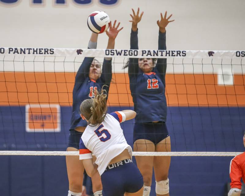 Oswego's Renee Eggers (11) goes up for a block with Laila Lawson (12) during volleyball match between Romeoville at Oswego. Oct 16, 2025.
