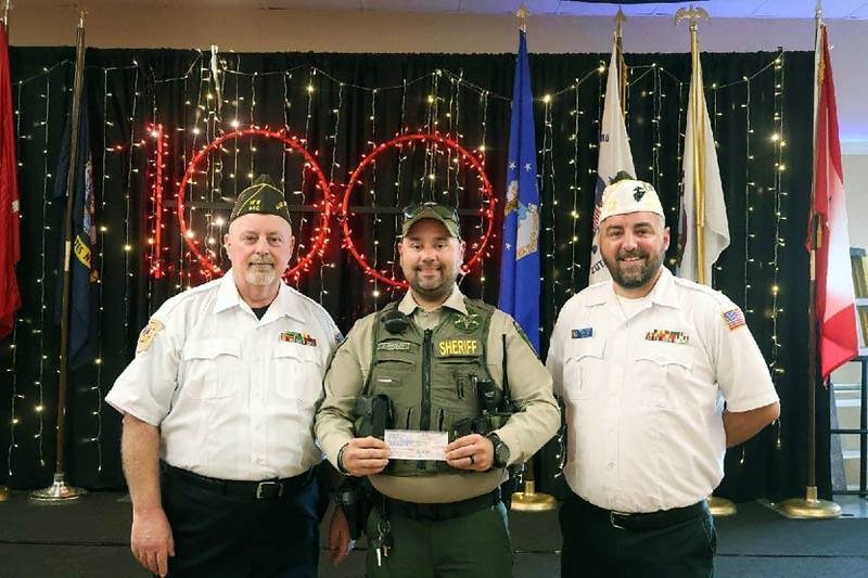 Lee County Sheriff's Office Deputy Joseph Presley accepts a donation from Dixon Veterans of Foreign Wars Post No. 540 for the Shopping with a Sheriff and K-9 programs.