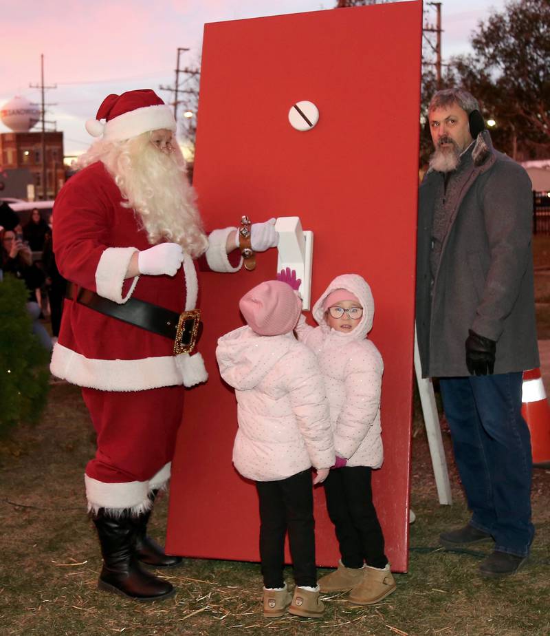 Santa and 5-year-old twins, Addie and Aubree Bachert of Sandwich, and Sandwich Mayor Todd Latham flip the light switch to light the Christmas Tree during A Merry Little Sandwich Christmas on Saturday, Dec. 7, 2024.