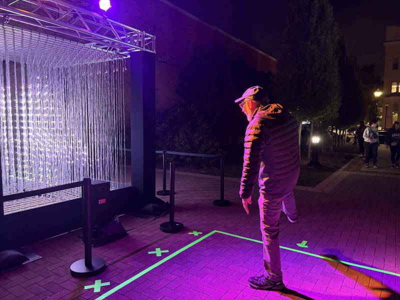 Jim Bossemeyer tries out the "Vivid Volume" installation on Oct. 10, 2025, part of the Lumenaura light and sound experience in downtown Aurora.