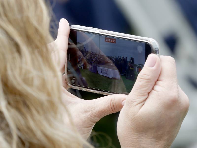 A teacher records the A Cappella Singers as they perform “The Kid Inside” during the graduation ceremony for the class of 2023 at Cary-Grove High School in Cary.