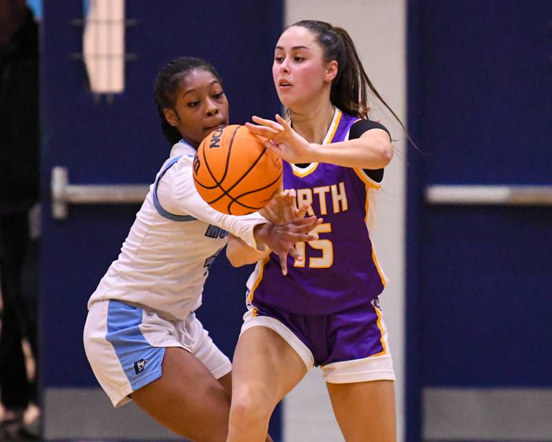 Downers Grove North's Adysen Fanta (15) passes the ball during the game on Saturday Dec. 21, 2024, while being defended by Downers Grove South's Hayven Harden (4) held at Downers Grove South High School.