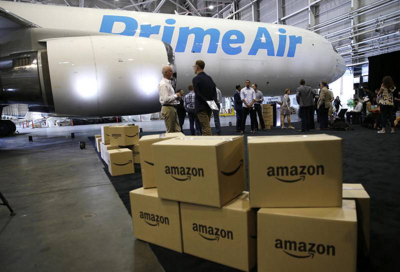 FILE - In this Thursday, Aug. 4, 2016, file photo, Amazon.com boxes are shown stacked near a Boeing 767 Amazon "Prime Air" cargo plane on display  in a Boeing hangar in Seattle. Amazon's announcement on Monday, Jan. 30, 2017, of a new air cargo hub in Kentucky is the latest way the e-commerce retailer is dipping its toe, or perhaps whole foot, into building out its shipping and logistics unit. If successful, the move ultimately means lower costs for Amazon but it could eventually pit Amazon against package deliverers like FedEx and UPS. (AP Photo/Ted S. Warren, File)