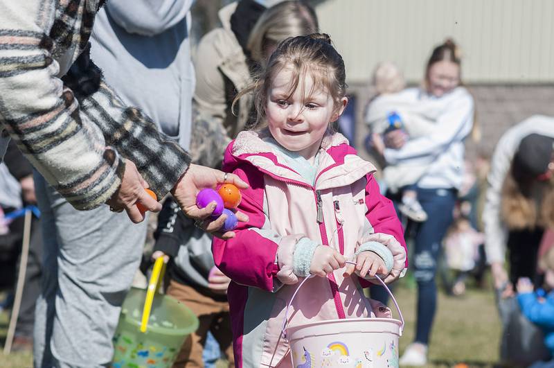 Addison Whitman, 3, gets a helping hand while gathering eggs Saturday, April 9, 2022 at the Dixon Park District egg hunt. The district had courses set up for different age groups to gobble up the treat filled eggs.
