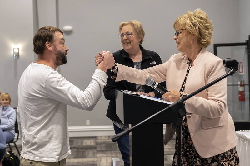 Andrew Kennedy shakes hands with director Pam Fluck after being named the G.O.A.T for the last year Thursday, Oct. 17, 2024, at the Self Help client awards banquet.