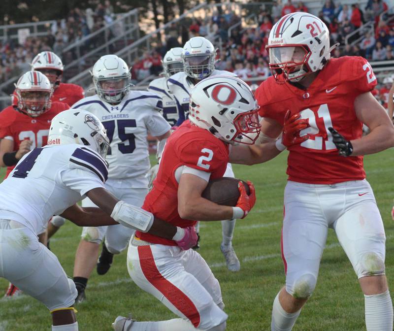 Oregon's Cooper Johnson (2) runs with the ball as Zandyr Withers (21) blocks against Rockford Lutheran on Friday, Sept. 5, 2025 at Landers-Loomis Field in Oregon. The Hawks beat the Crusaders 40-8.
