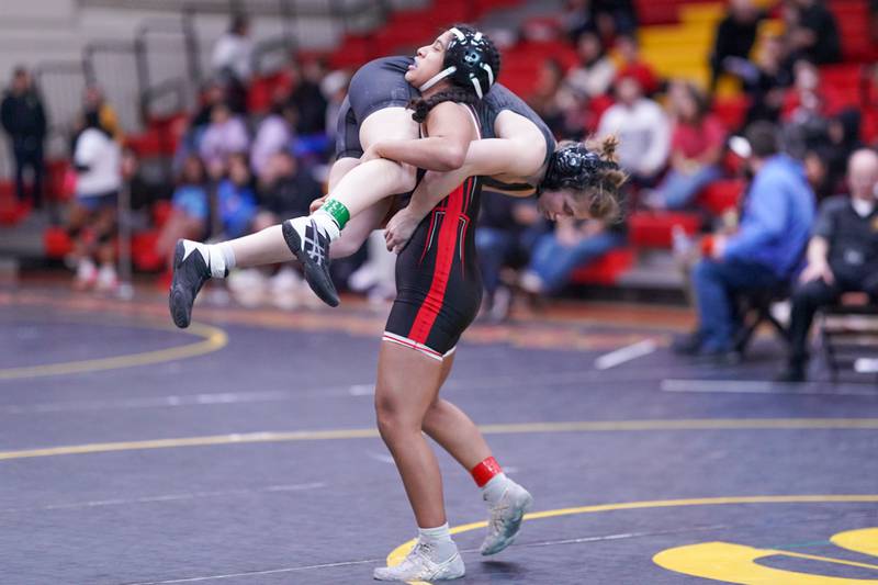 Bolingbrook’s Katie Ramirez-Quinter lifts Elmwood Park’s Rose Craig off the mat during their 135 pound championship match in the Schaumburg Girls Wrestling Sectional at Schaumburg High School on Saturday, Feb 10, 2024.