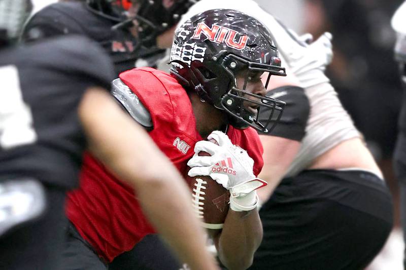 Northern Illinois University running back Harrison Waylee breaks through the line during spring practice Wednesday, April 6, 2022, in the Chessick Practice Center at NIU in DeKalb.