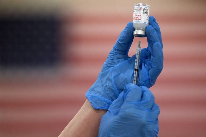 Crista Mundil, a nursing student at McHenry County College and volunteer at the COVID-19 vaccination clinic at Huntley High School, fills a syringe with the Moderna COVID-19 vaccine on Friday, March 12, 2021, in Huntley.