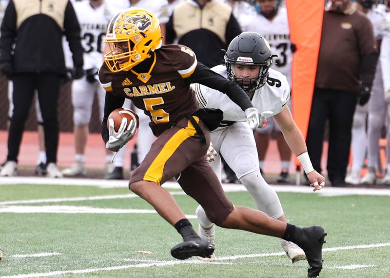 Carmel's Jarren Black runs past Sycamore's Dawson Alexander during their Class 5A second round playoff game Saturday, Nov. 5, 2022, at Carmel Catholic High School in Mundelein.