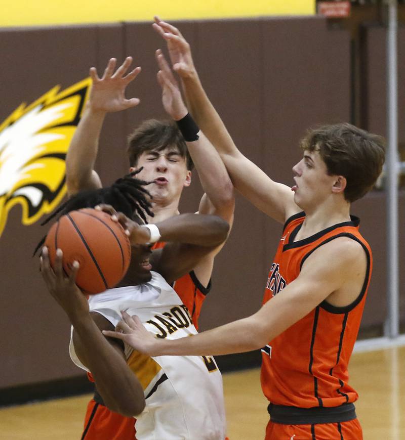 McHenry's Adam Bronowicki (center) and Caleb Jett (left) apply pressure to Jacobs' Treval Howard as he tries to bring the ball up the court during a Fox Valley Conference boys basketball game on Wednesday, Nov. 29, 2023, at Jacobs High School in Algonquin.