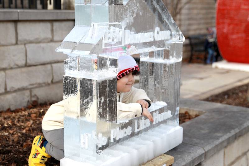 Oliver Montejano, 5, sticks his head through one of the ice sculptures on display during the Downtown Downers Grove Ice Festival on Saturday, Feb. 1, 2025 in Downers Grove.