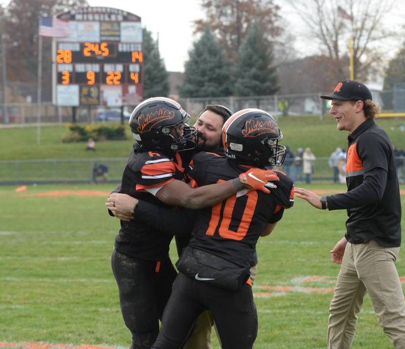 Milledgeville's Micah Toms-Smith (6) and Evan Schenck (10) celebrate with their coaches in the final seconds of their 28-14 win over Polo during 8-man semi-final playoff action on Saturday, Nov. 16, 2024 at Milledgeville.