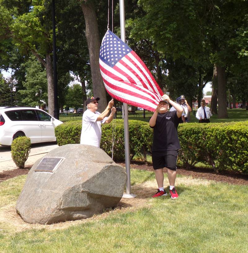 Bob Harrison (left) and Alex Wickman prepare the American flag for half staff on Monday, May 27, 2024, during the Memorial Day ceremony in Veterans Memorial Plaza at City Park in Streator.